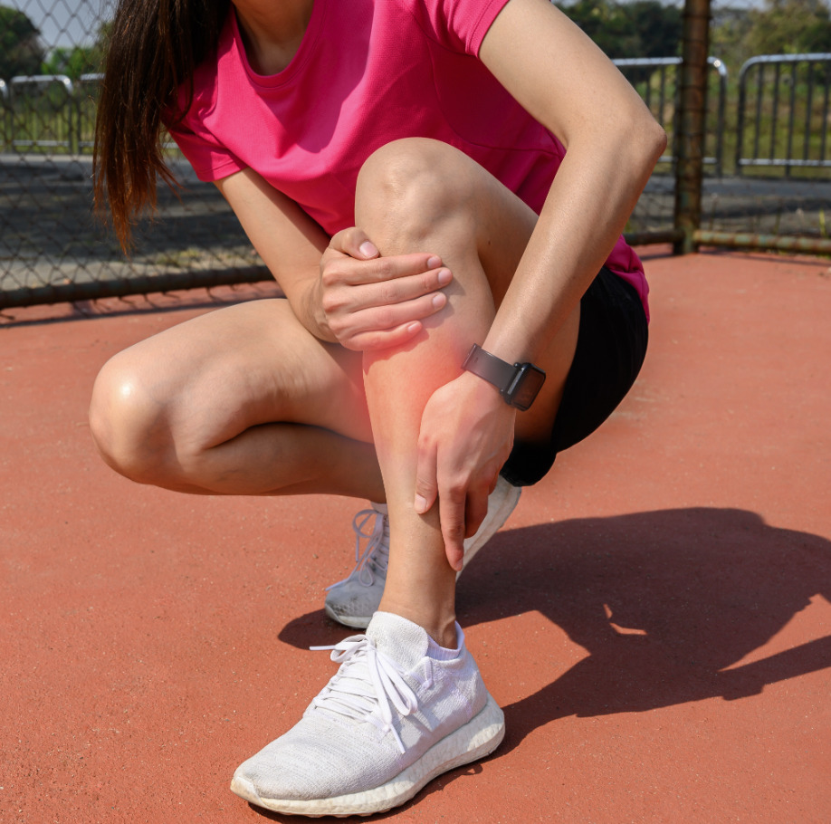 bild på kvinna med ont i vänster ben under träning bild på kvinna med ont i vänster ben under träning