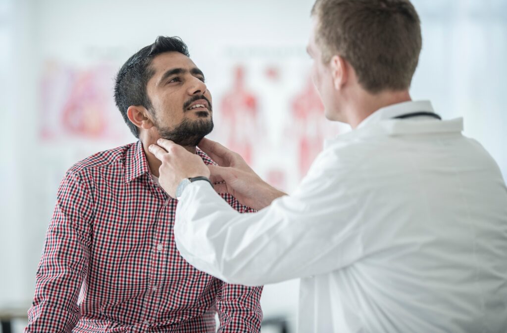 läkare undersöker hals på patient